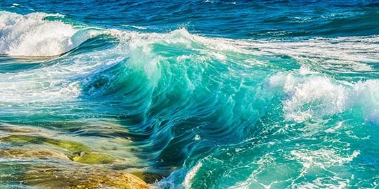 frothy-ocean-waves-break-over-rocks_550x275